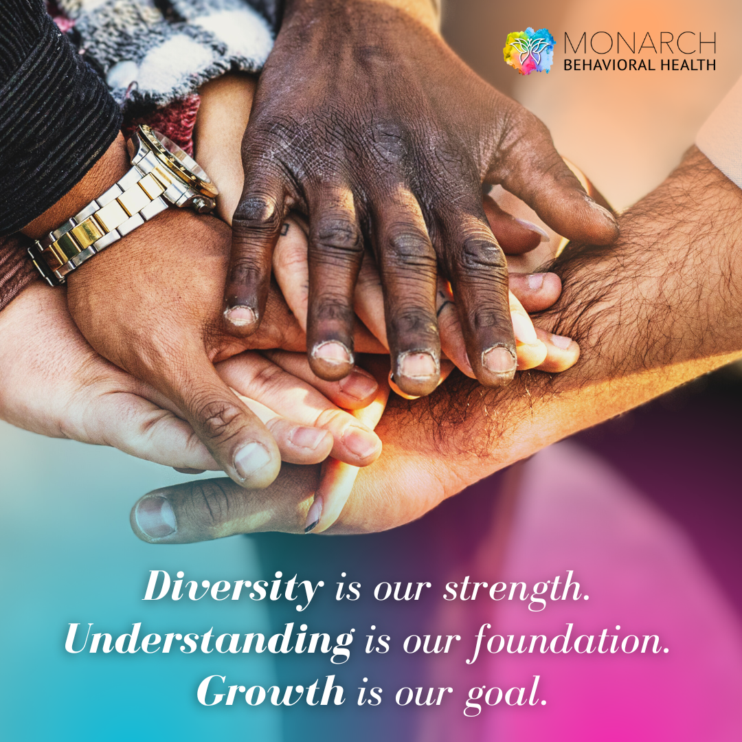 Diverse group of hands stacked together in a gesture of unity, illustrating the Monarch team’s shared values of diversity, understanding, collaboration, and collective growth.