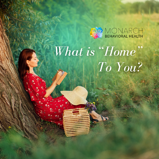 Person sitting against a tree in a peaceful outdoor setting, reading and reflecting, illustrating the question what does home mean to you and the feeling of safety, comfort, and belonging.