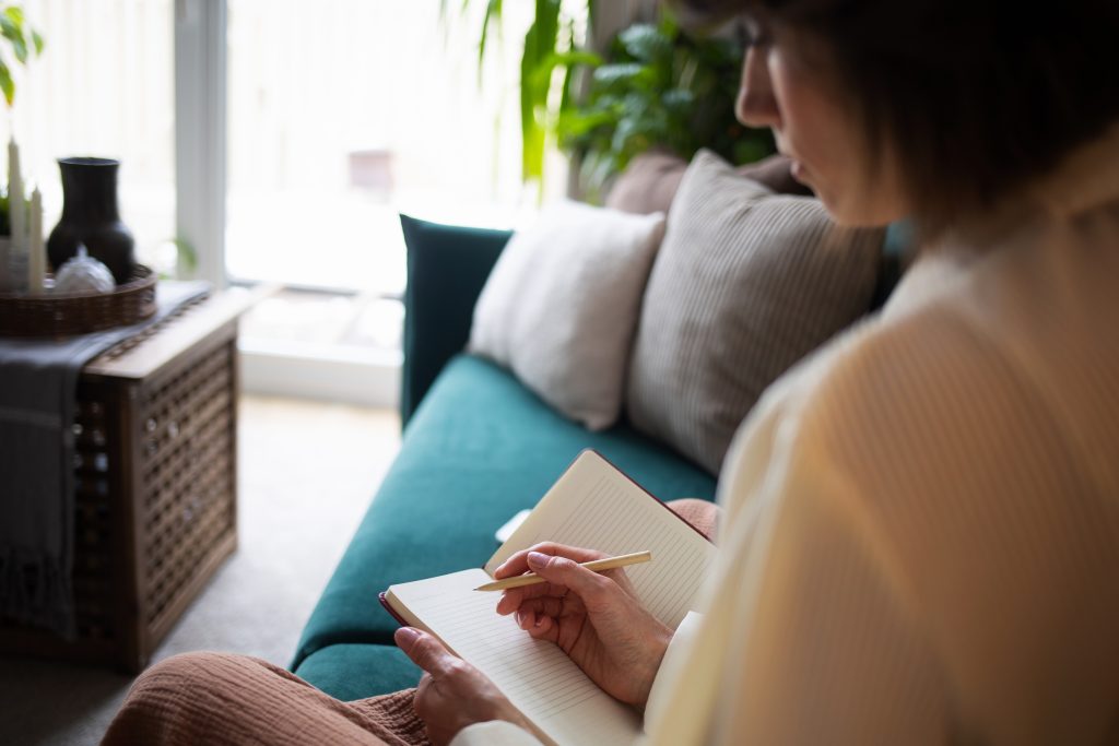 Therapist talking with a client on a sofa in a cozy living room.