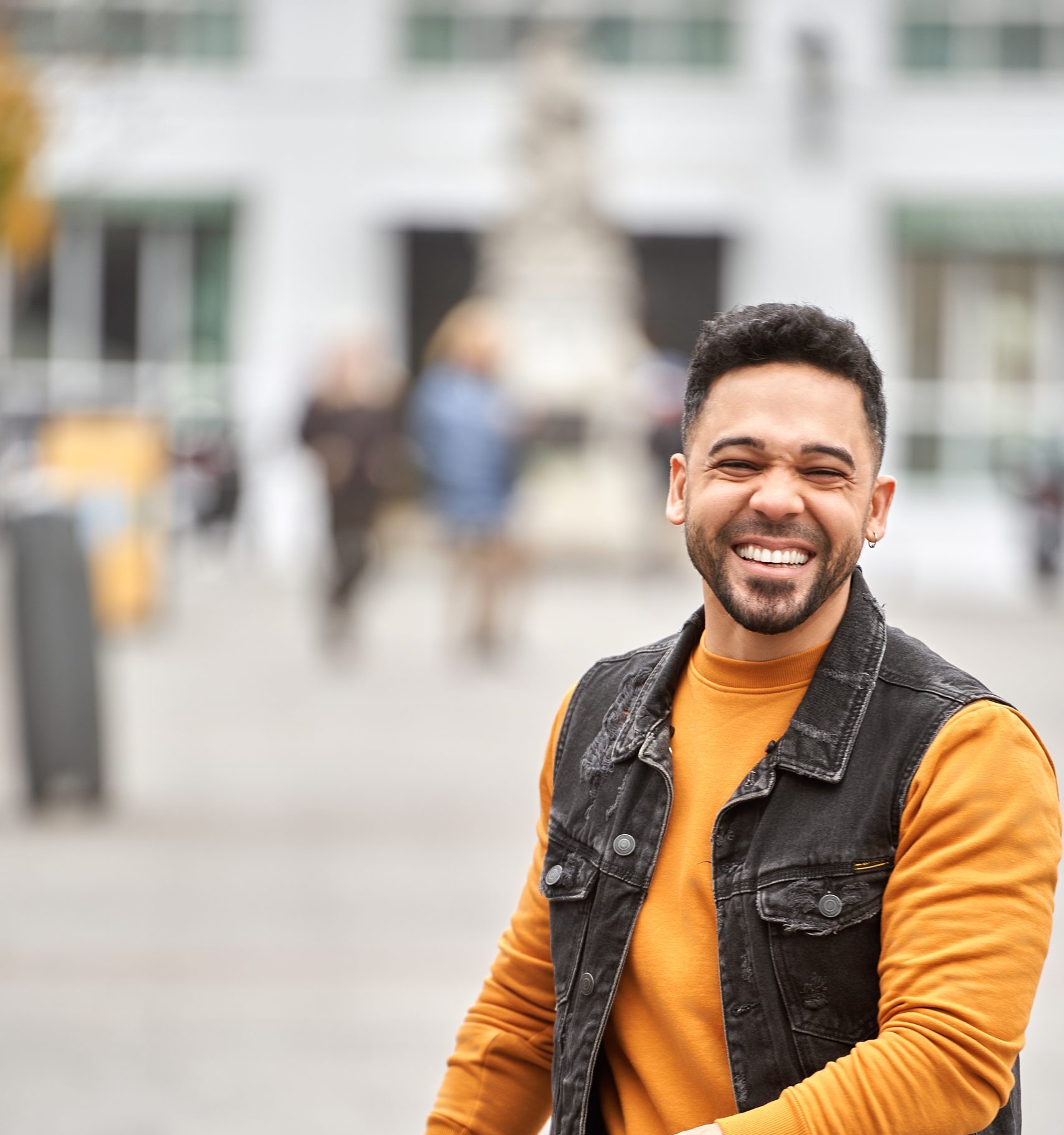 Man smiling while standing on the street. Positivity concept.