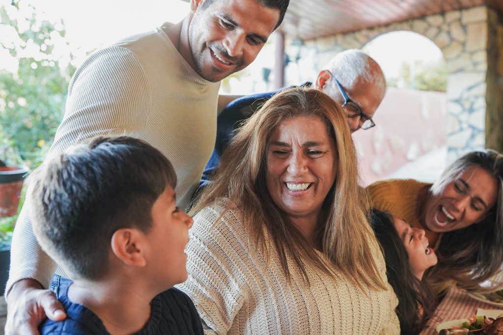 Happy latin family having fun together after lunch at house terrace